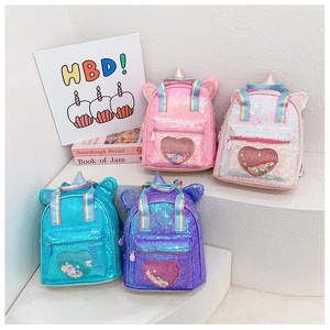Detail of sequin unicorn backpack showing heart shaker pocket and rainbow straps