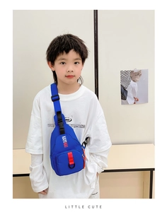 Close-up of blue nylon kids chest bag with adjustable strap and red branded webbing