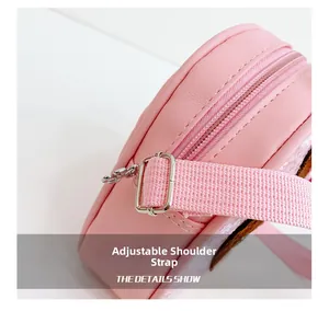 Close-up of the pink adjustable woven shoulder strap with metal buckle on kids handbag