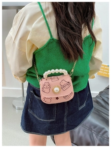 Détail du mini sac bandoulière rose pour fille avec poignée perle et motifs capybara