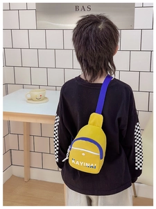 Detail of a lightweight yellow canvas kids chest bag with blue KAYINAI lettering and straps