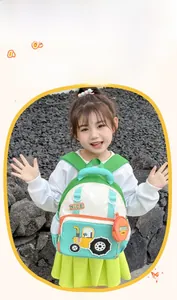 Detail of cartoon tractor backpack showing the side mesh pocket and round orange coin purse