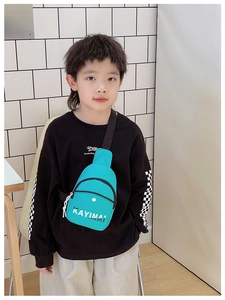 Detail of the teal nylon kids chest bag featuring white logo text and black zipper