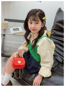 Détail d'un mini sac rouge pour enfant avec poignée en perles et chaîne dorée