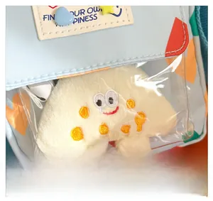 Detail of children's blue canvas bag featuring transparent PVC pocket and plush mascot