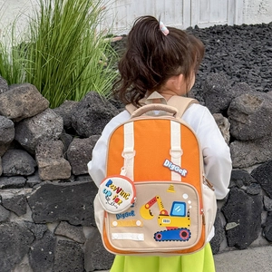 Orange excavator themed kids backpack with matching mini coin pouch on outdoor model
