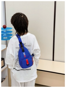 Rear view of a child wearing a blue nylon chest bag with adjustable black strap