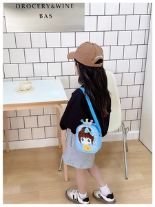 Sky blue kids crossbody bag with sequined girl design and crown detail in lifestyle view
