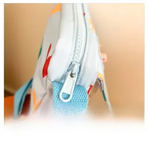 Detail view of smooth blue resin zipper and colorful printed fabric on kids crossbody bag