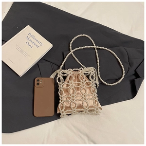 Vue détaillée d'un sac seau en perles avec doublure en satin champagne et cordon de serrage