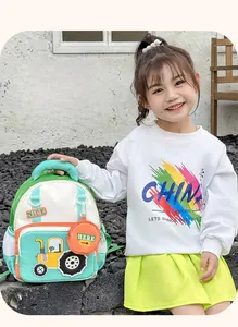 Close-up of kids tractor backpack with durable nylon fabric and orange coin purse charm
