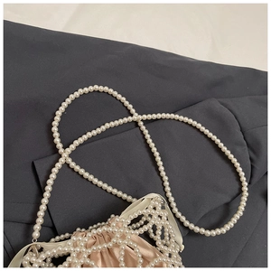 Détail du sac à main en perles avec doublure en satin champagne et cordon de serrage