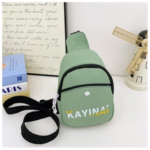 Detail of light green crossbody bag with letter print and adjustable black nylon strap