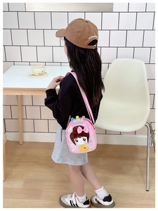 Detail view of pink sequin girl's crossbody bag with silver crown and plush pom-poms