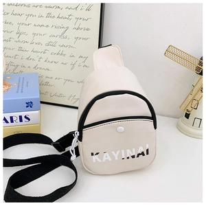 Close-up of cream crossbody bag featuring black letter logo and front snap button pocket