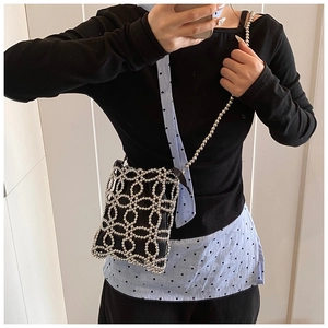Selfie montrant un sac seau argenté à perles avec motif floral évidé et cordon intérieur