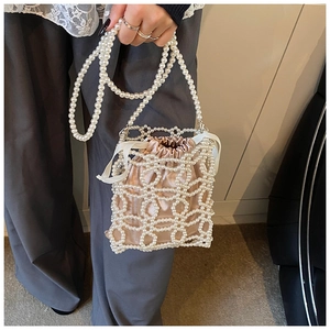 Détail du sac seau perlé à la main avec doublure en satin et bandoulière en perles