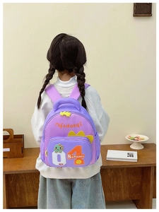 Rückansicht eines Kindes mit lila Dino-Rucksack in einer gemütlichen häuslichen Umgebung