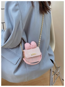 Detailed view of pink lace crossbody bag with decorative bow and golden chain strap