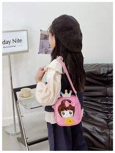 Detailed side view of pink sequin crossbody bag for girls with crown and bow on sofa