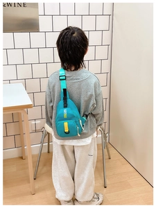 Detailed back view of a light blue kids chest bag with adjustable black buckle strap