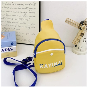 Detail of a bright yellow crossbody bag with blue zipper and bold white letter print