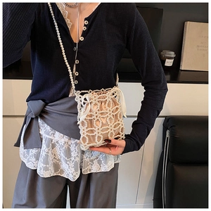 Détail du sac seau perlé à la main avec doublure en satin de couleur champagne