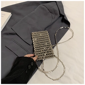 Détail montrant la texture tissée d'un mini sac bandoulière en perles argentées