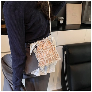 Détail d'un sac seau en perles fait main avec doublure en satin et fermeture à cordon