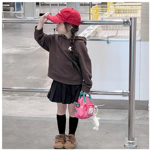 Girl wearing a pink printed handbag and brown hoodie in a trendy street style outfit