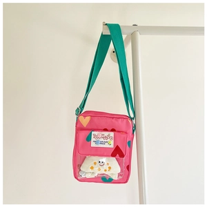 Detail of pink heart-patterned kid's bag featuring a clear PVC pocket with a plush toy insert