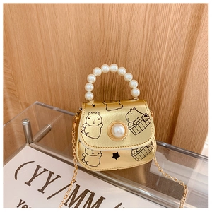 Détail d'un mini sac doré pour fille avec poignée en perles et imprimé de capybara