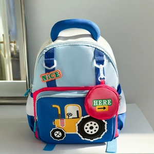 Close-up of children's blue backpack with a yellow tractor patch and a red round pouch