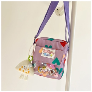 Detail of purple crossbody bag with colorful hearts, clear window and mushroom charm