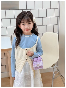 Detail of lavender lace mini crossbody bag with golden chain and bow on a child model