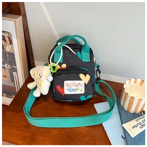 Detail of kids canvas crossbody bag with heart prints and white plush cloud charm