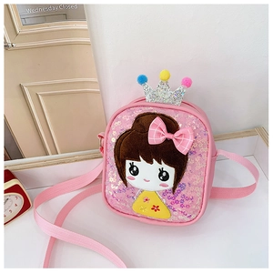 Detail of pink sequin girl's crossbody bag featuring a cute crown and fluffy pom-poms