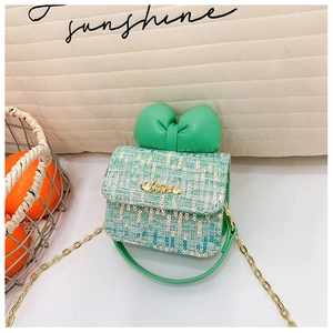 Detail view of mint green tweed mini crossbody bag with large bow and gold Love metal tag