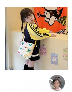 Vue détaillée du sac bandoulière enfant en toile avec motifs cœurs et petit pendentif