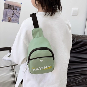 Kid's mint green nylon chest bag with letter print shown on model for outdoor travel