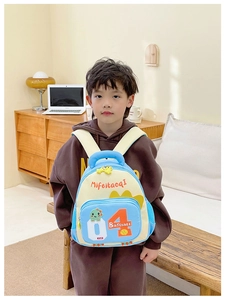 Detail eines leichten Kinderrucksacks mit süßem grünem Dinosaurier und Baseball-Motiv