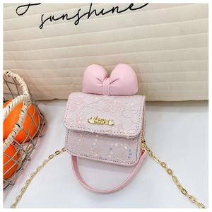 Detail of pink lace mini crossbody bag with a large bow and gold metal Love charm