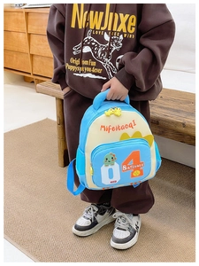 Detaillierte Nahaufnahme des blauen Kinderrucksacks mit Dino-Motiv in gemütlicher Umgebung