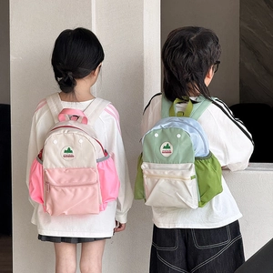 Detail of color-block kids backpacks featuring front zipper pockets and side mesh bottle holders