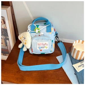 Detail of light blue kids heart crossbody bag with cloud plush charm and zip pocket