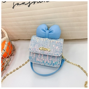 Detail of tweed mini crossbody bag featuring a large blue bow and gold Love buckle