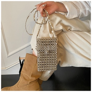 Détail des perles métalliques argentées sur un petit sac à bandoulière artisanal