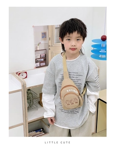 Detail of beige canvas kids chest bag featuring cartoon print and adjustable strap