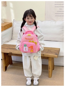 Detailansicht eines rosa Kinderrucksacks mit Cartoon-Dinosaurier und seitlicher Netztasche