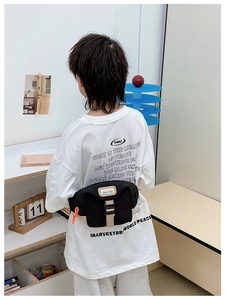 Détail du sac banane en toile avec logo, boucle de fermeture et cordon orange vif